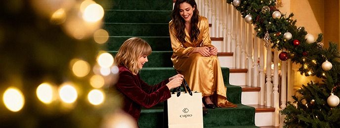 Zwei Frauen überreichen sich ein Geschenk an Weihnachten